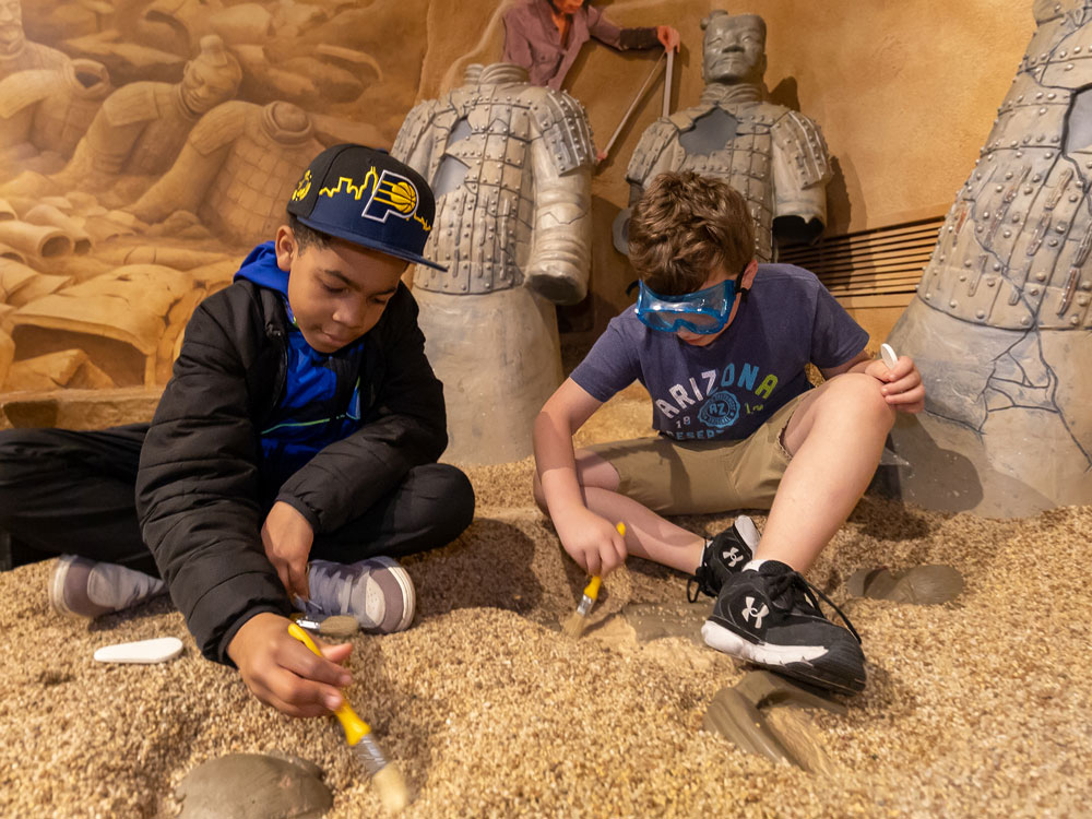 Children digging in National Geographic Treasures of the Earth exhibit.